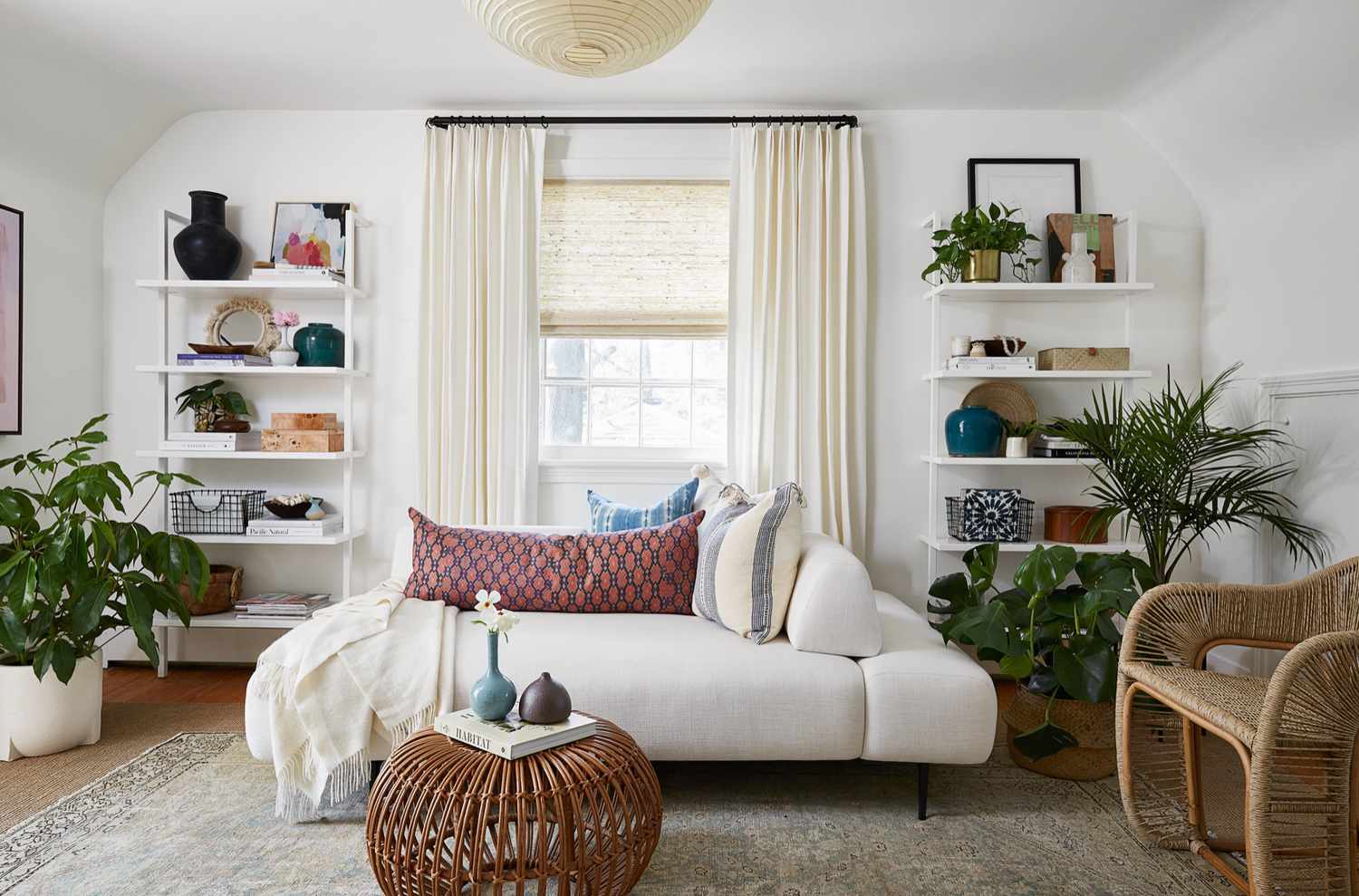 Ein cremeweißes Wohnzimmer mit einer pfirsichfarbenen Decke als Blickfang