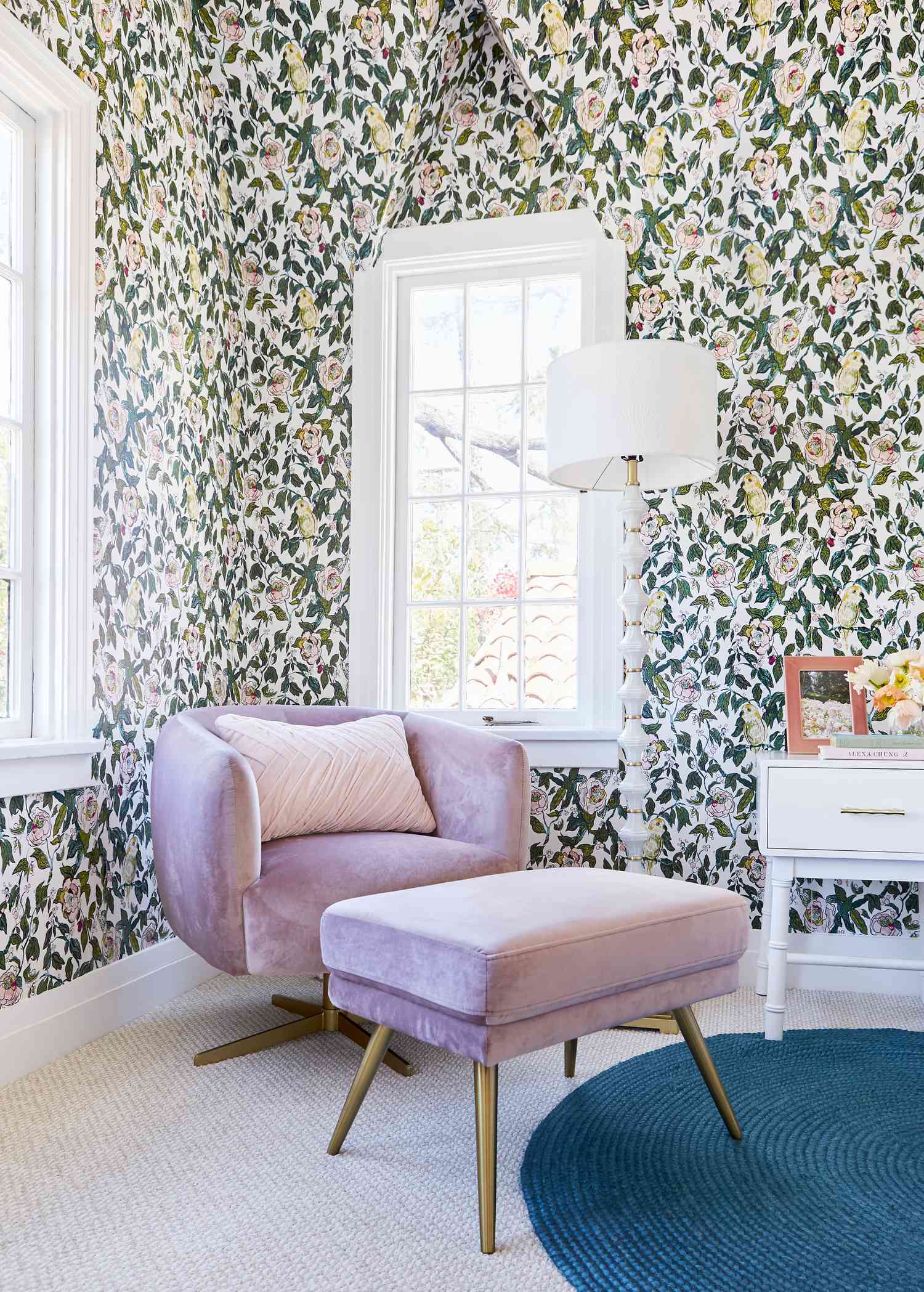 Coin d'inspiration cottage avec chaise en velours rose, papier peint floral, et tapis rond sarcelle