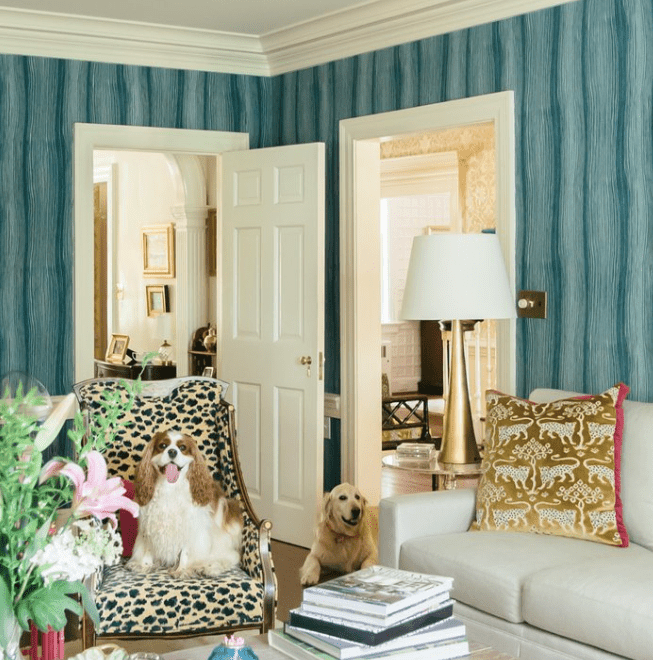 Sala maximalista em azul-petróleo com cadeira de leopardo, luminária de latão e travesseiro de leopardo dourado