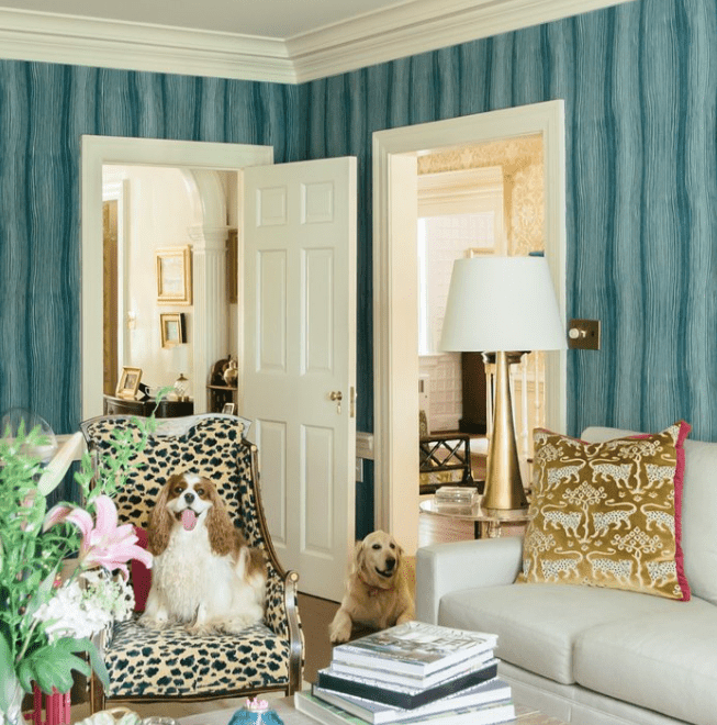 Habitación maximalista verde azulado con silla de leopardo, lámpara de latón y cojín de leopardo dorado