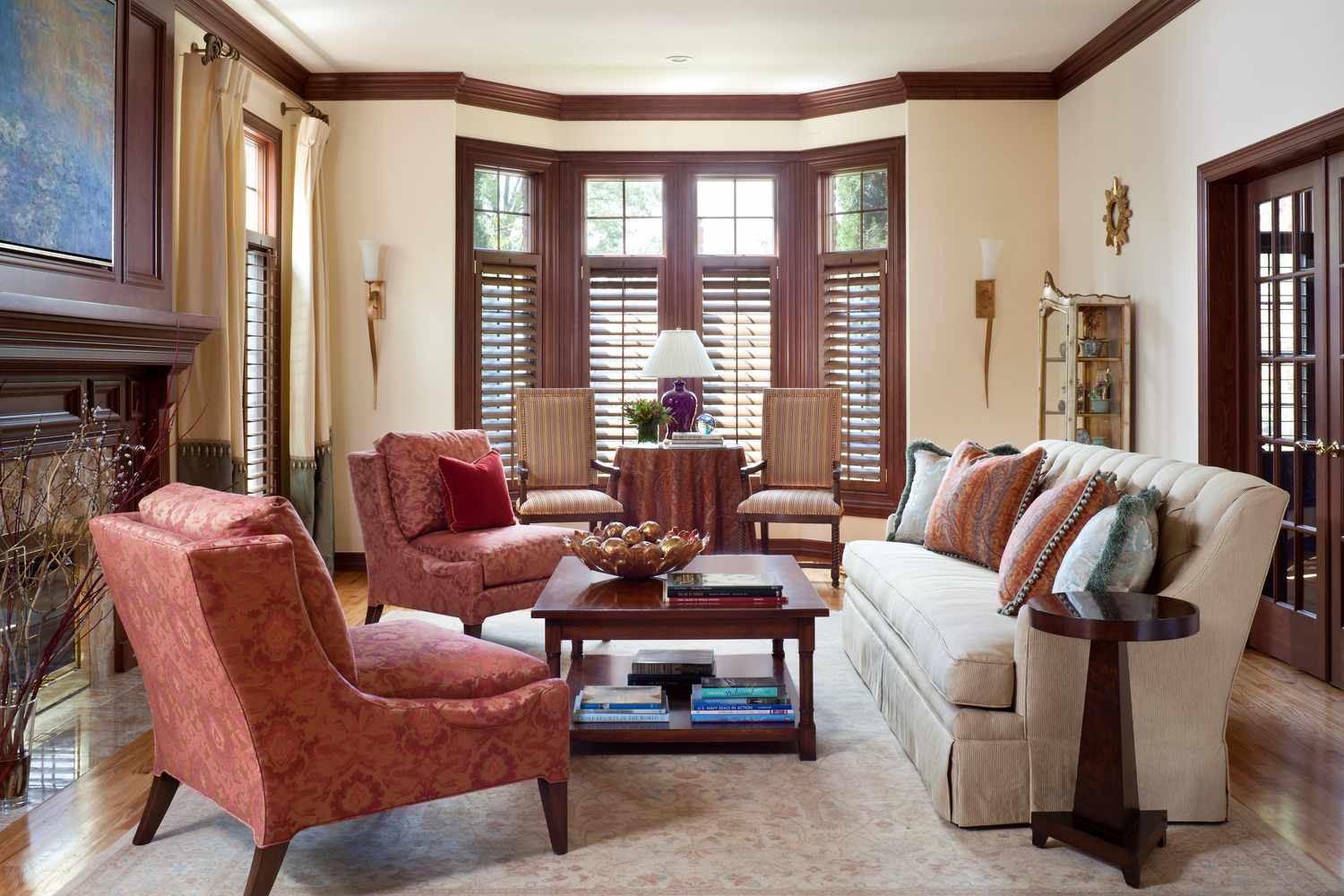 Ein Wohnzimmer hat pfirsichfarbene Wände, die mit reichem, fast rotem Holz verkleidet sind. Auch die Türöffnungen sind mit Holz verkleidet
