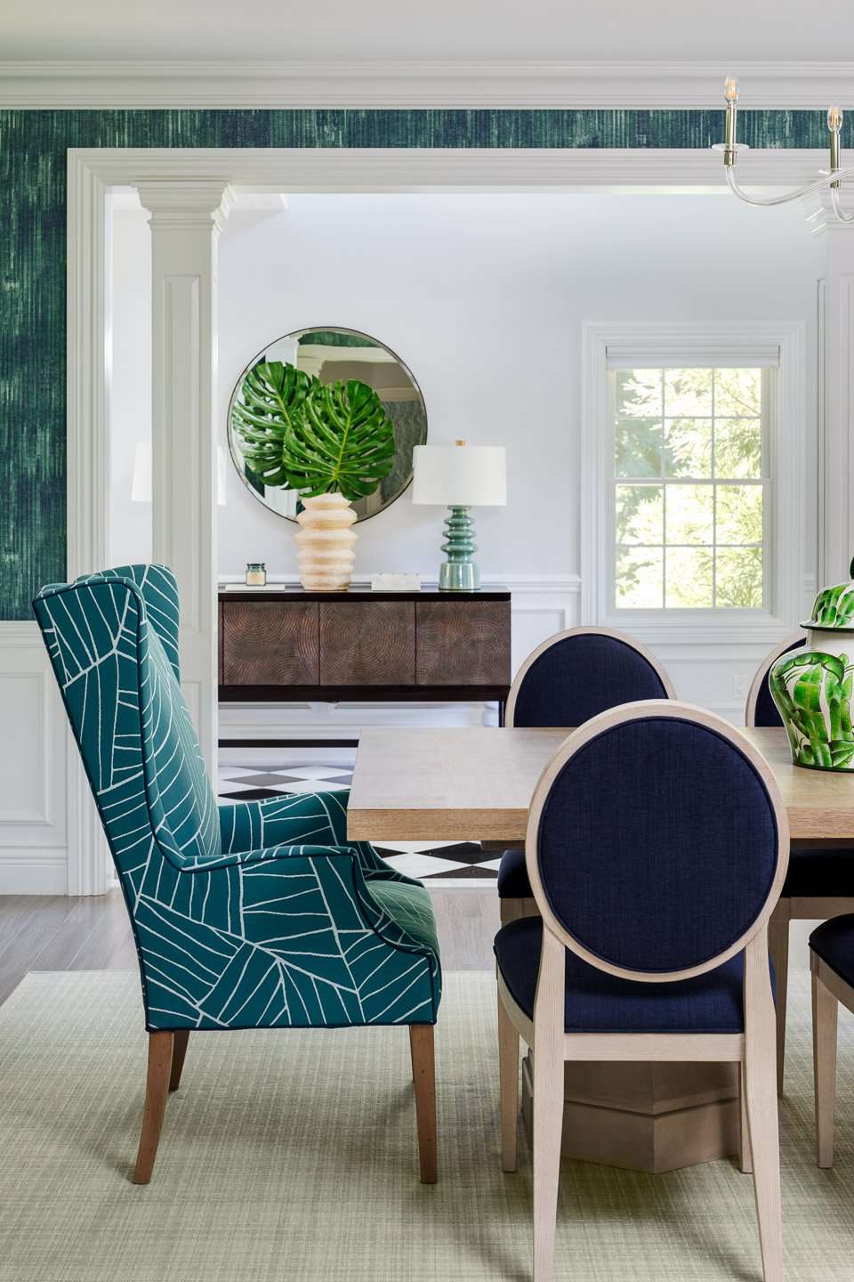Teal dining room with teal wingback chairs and wallpaper 