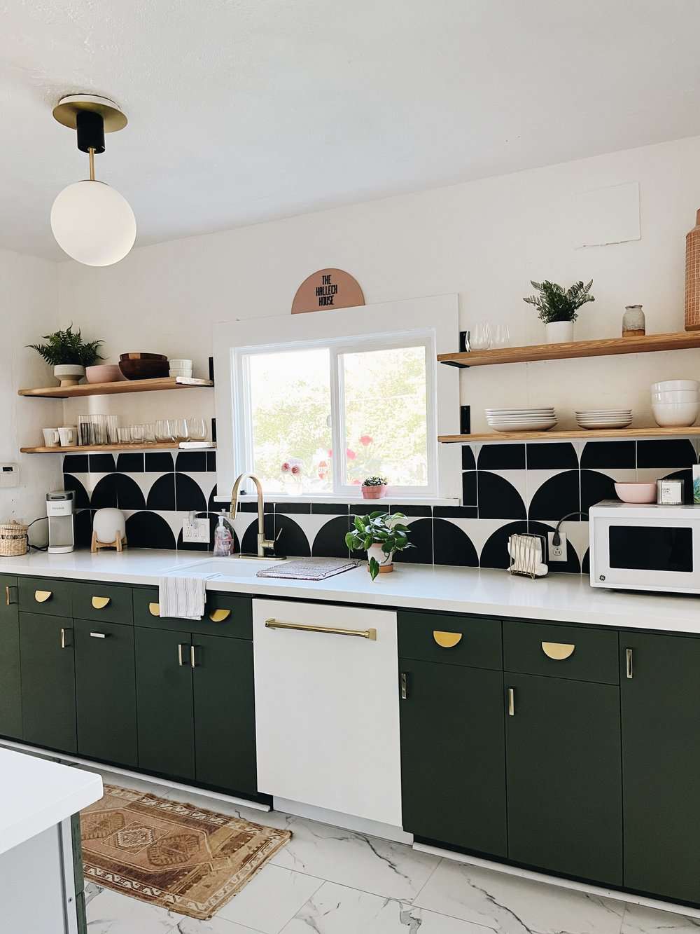 green cabinets and black and white backsplash