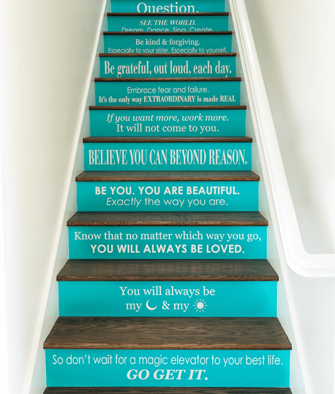 Uma escada com degraus pintados com citações inspiradoras