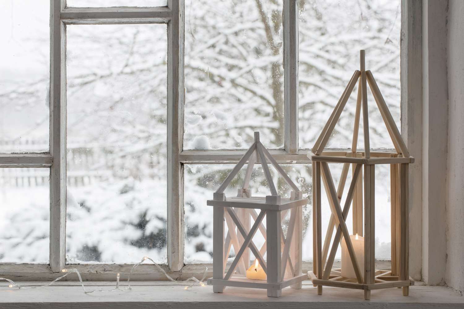 two white lanterns on windowsill