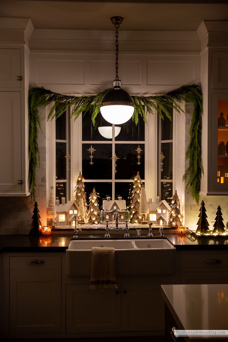 pueblo navideño iluminado en el alféizar de la ventana