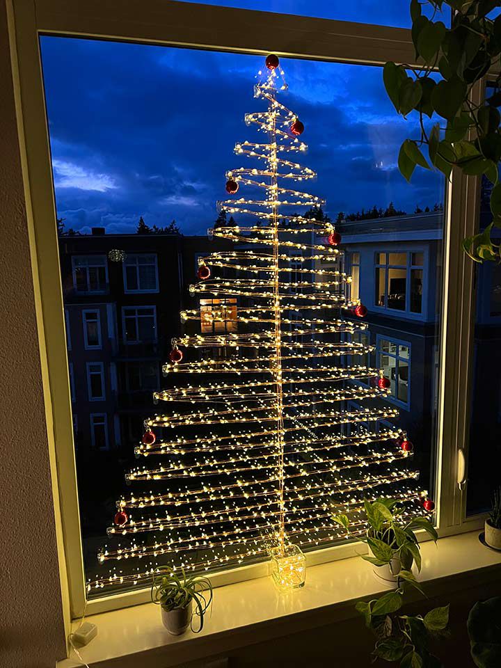 ventana con luces en forma de árbol de Navidad