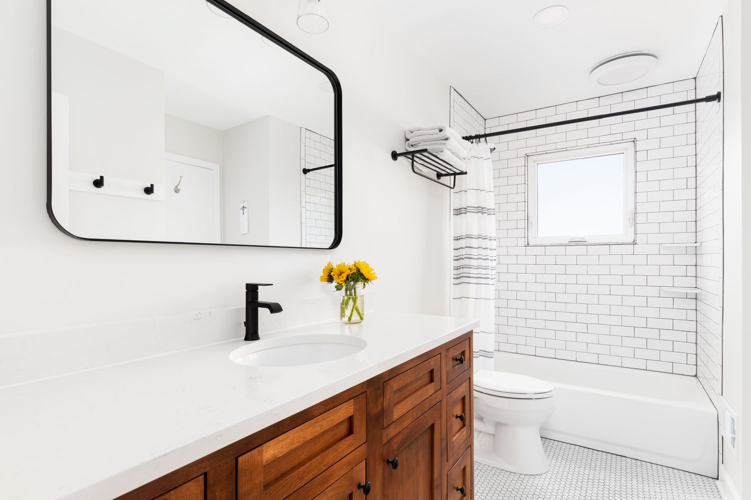 Um banheiro com azulejo branco e rejunte preto
