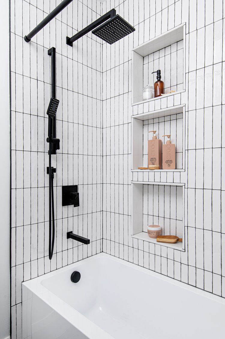 Banheiro pequeno preto e branco com azulejos verticais no metrô