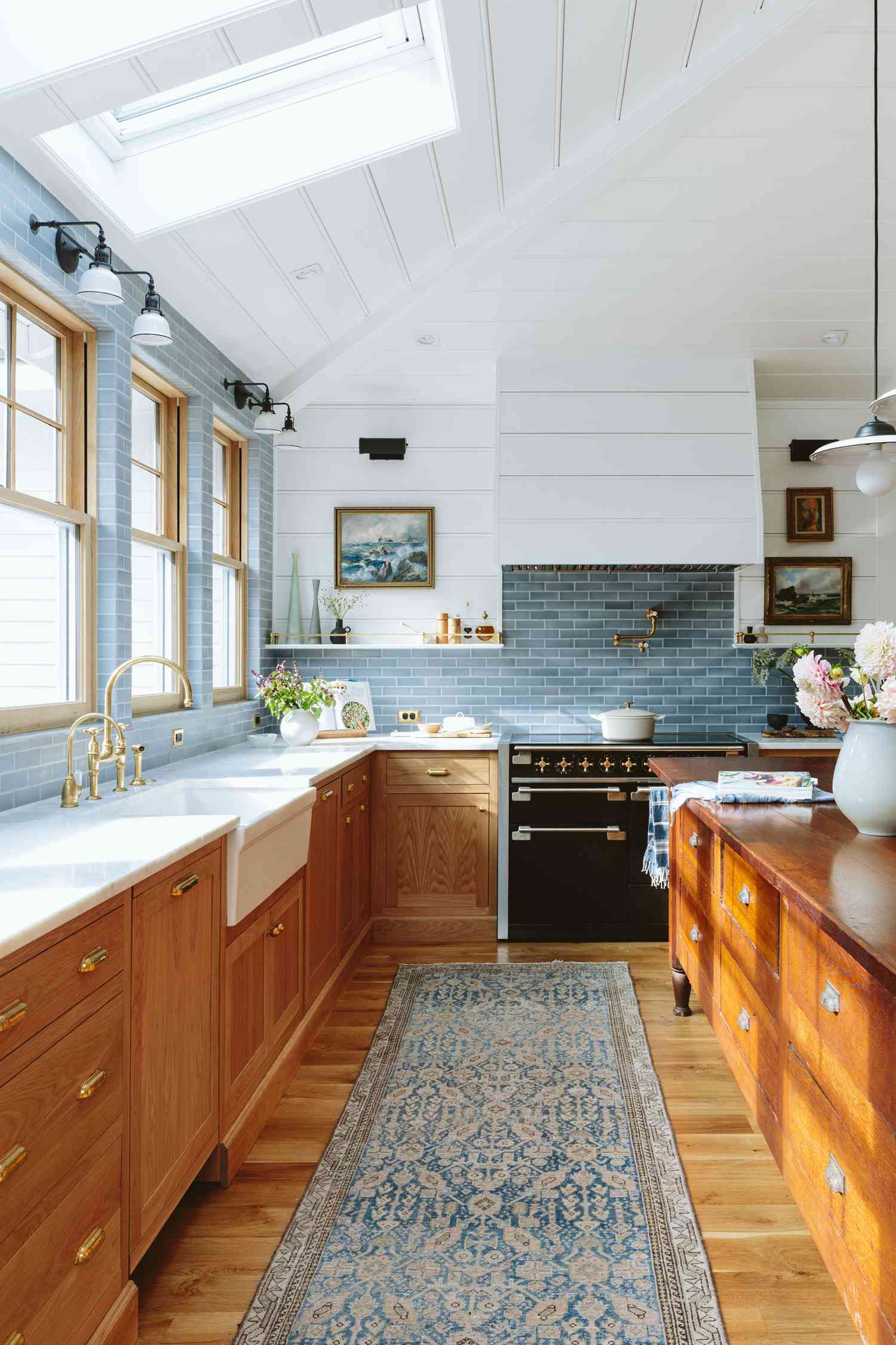 Cozinha com armários de carvalho, bancadas de mármore e backsplash de azulejos de metrô azuis