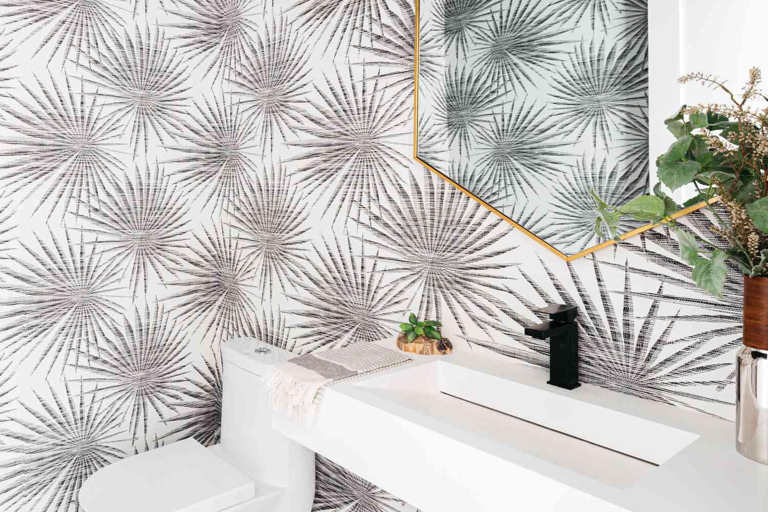 Mur de salle de bain avec papier peint à motif feuillage avec plantes d'intérieur près du lavabo