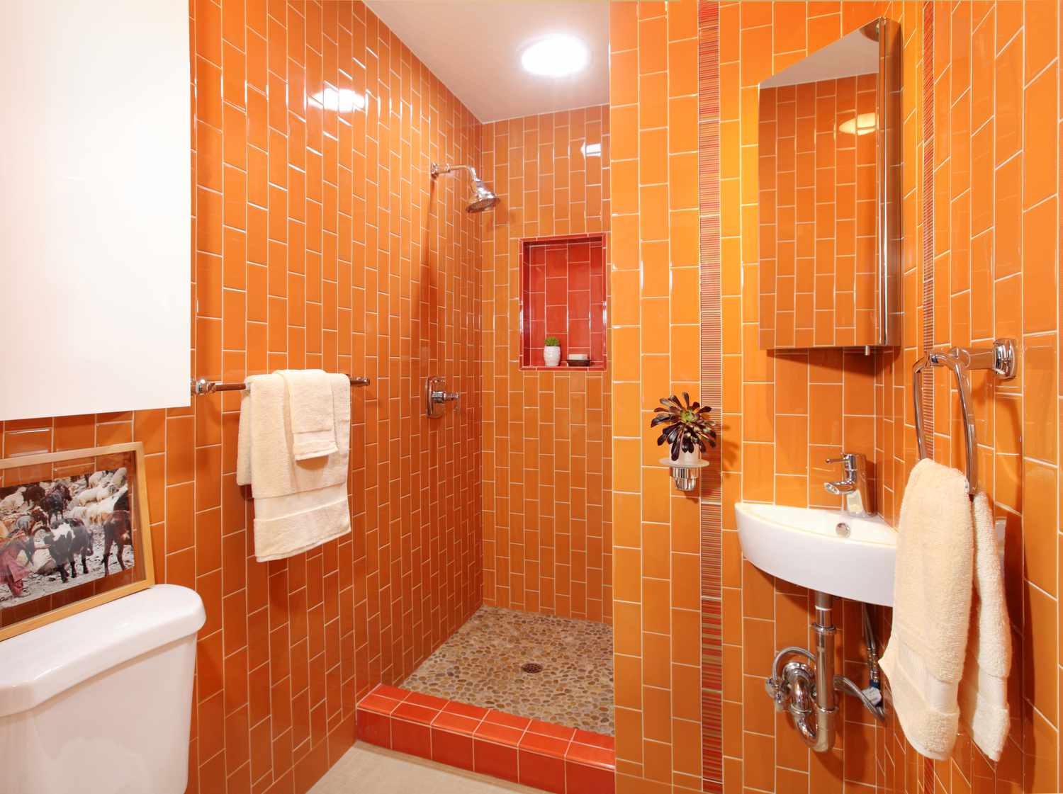 Salle de bain lumineuse et énergisante avec une palette de couleurs orange monochromatique.