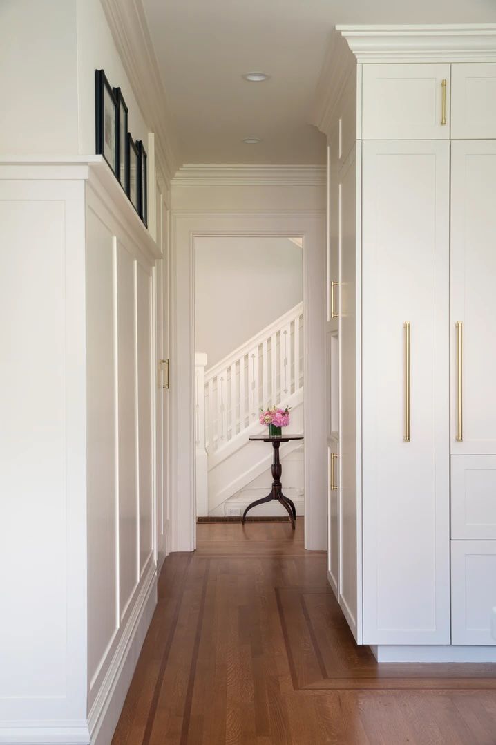 Pictures above wainscoting in a narrow hallway