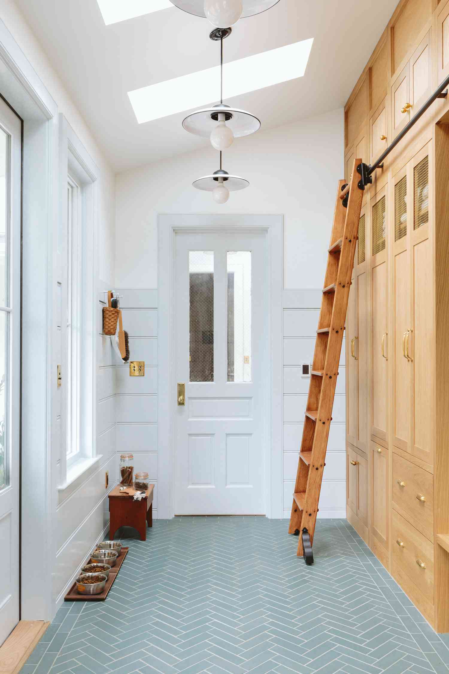 Wooden rolling ladder attached to built-ins in a narrow hallway
