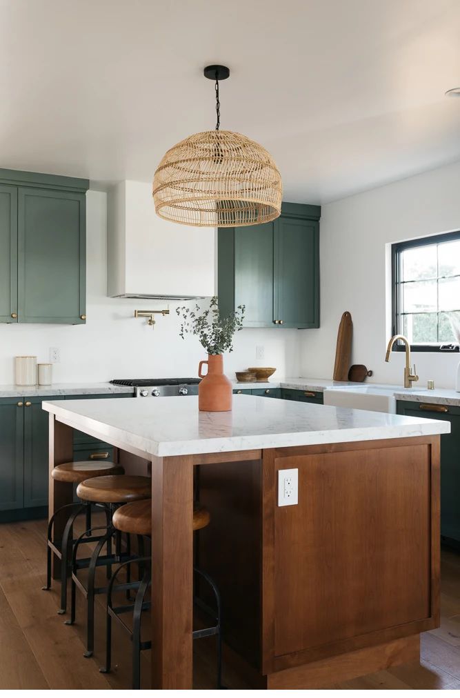 Uma cozinha com armários verdes e uma ilha de madeira