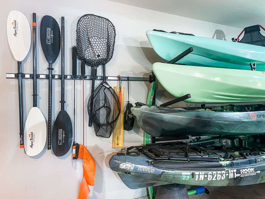 Caiaques e equipamentos de pesca montados na parede em uma garagem