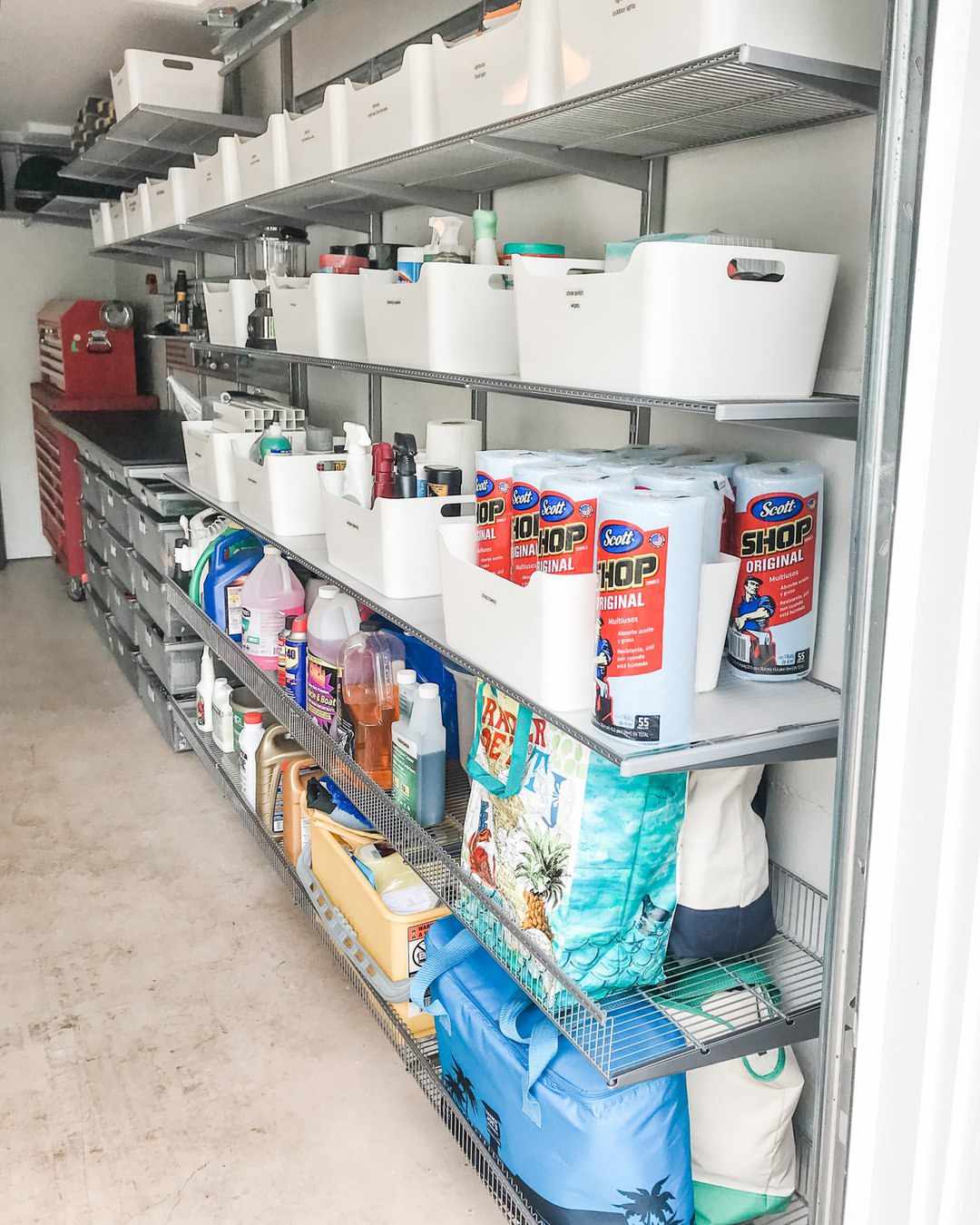 Cleaning supplies stored in plastic bins on garage shelves