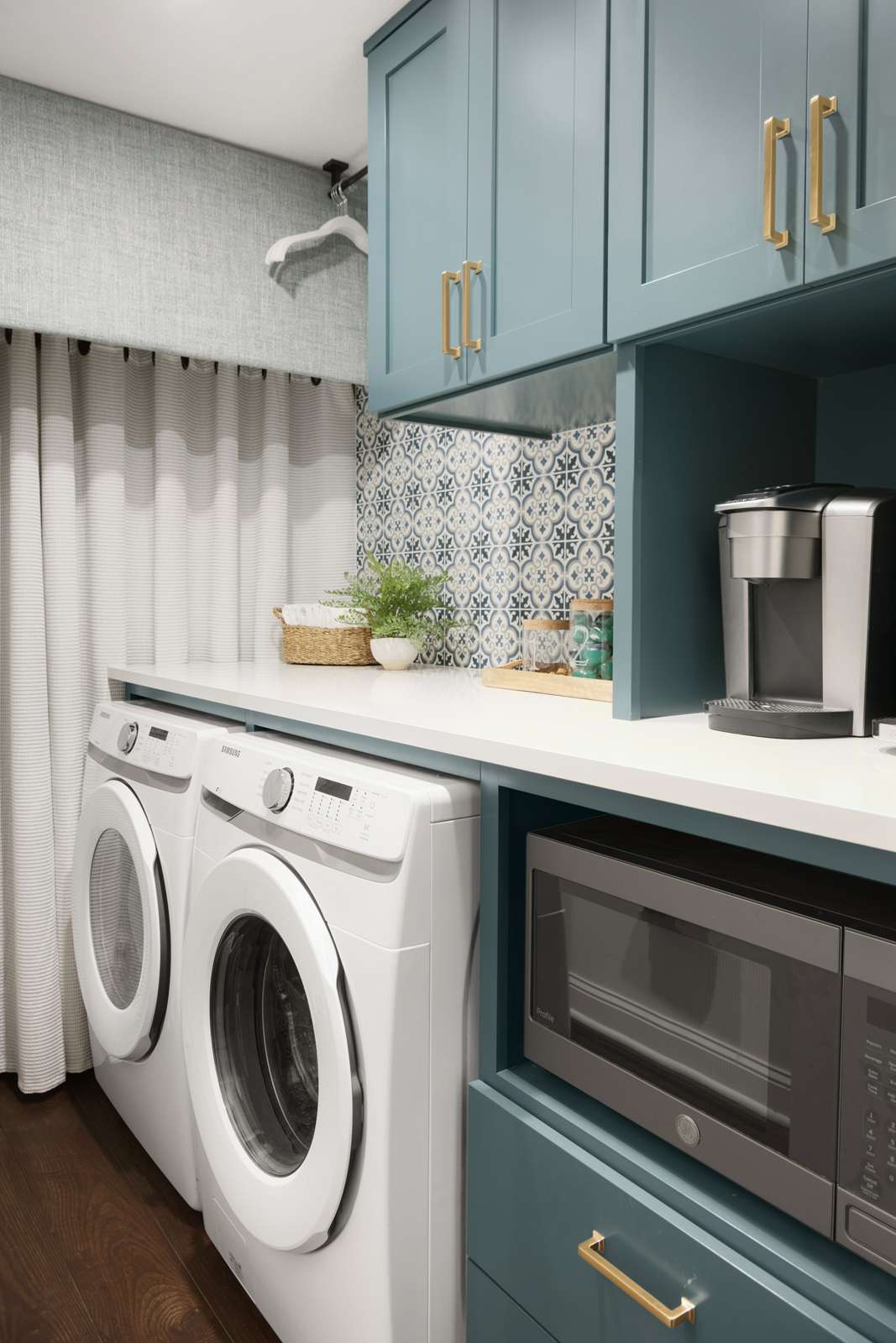 Waschküche mit blauen Schränken und grafischen Wandfliesen
