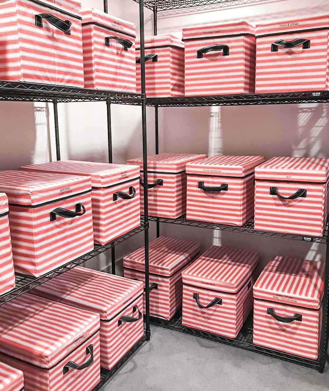 Caixas de armazenamento listradas de vermelho e branco em prateleiras industriais pretas