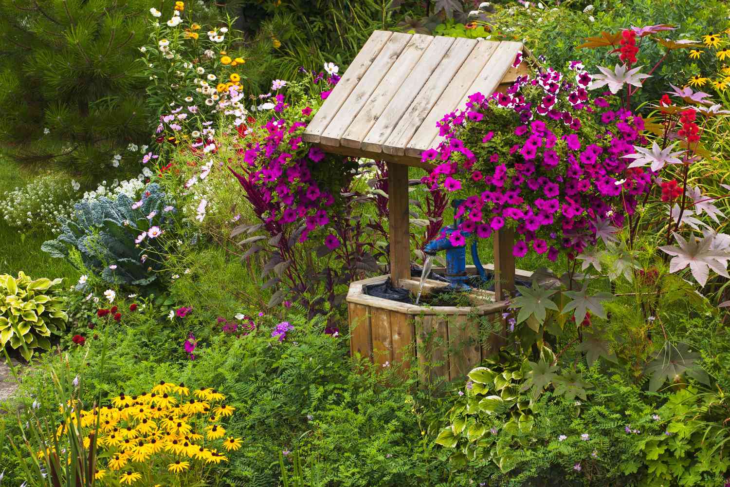Blumen in einem Garten mit einem Wunschbrunnen