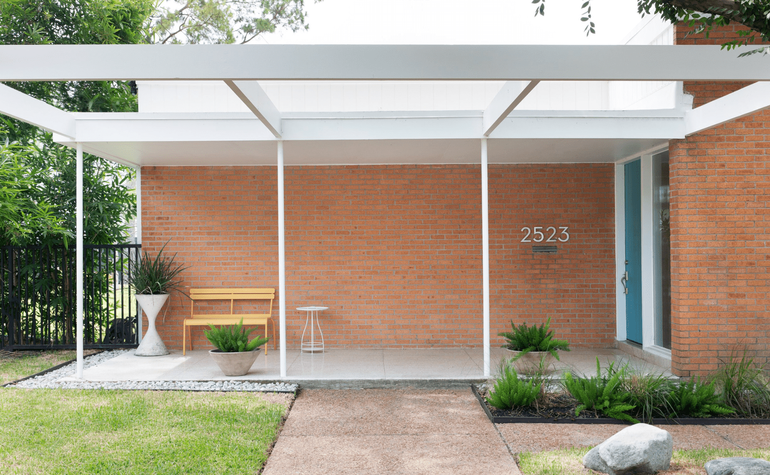 midcentury modern home with brick exterior and patio