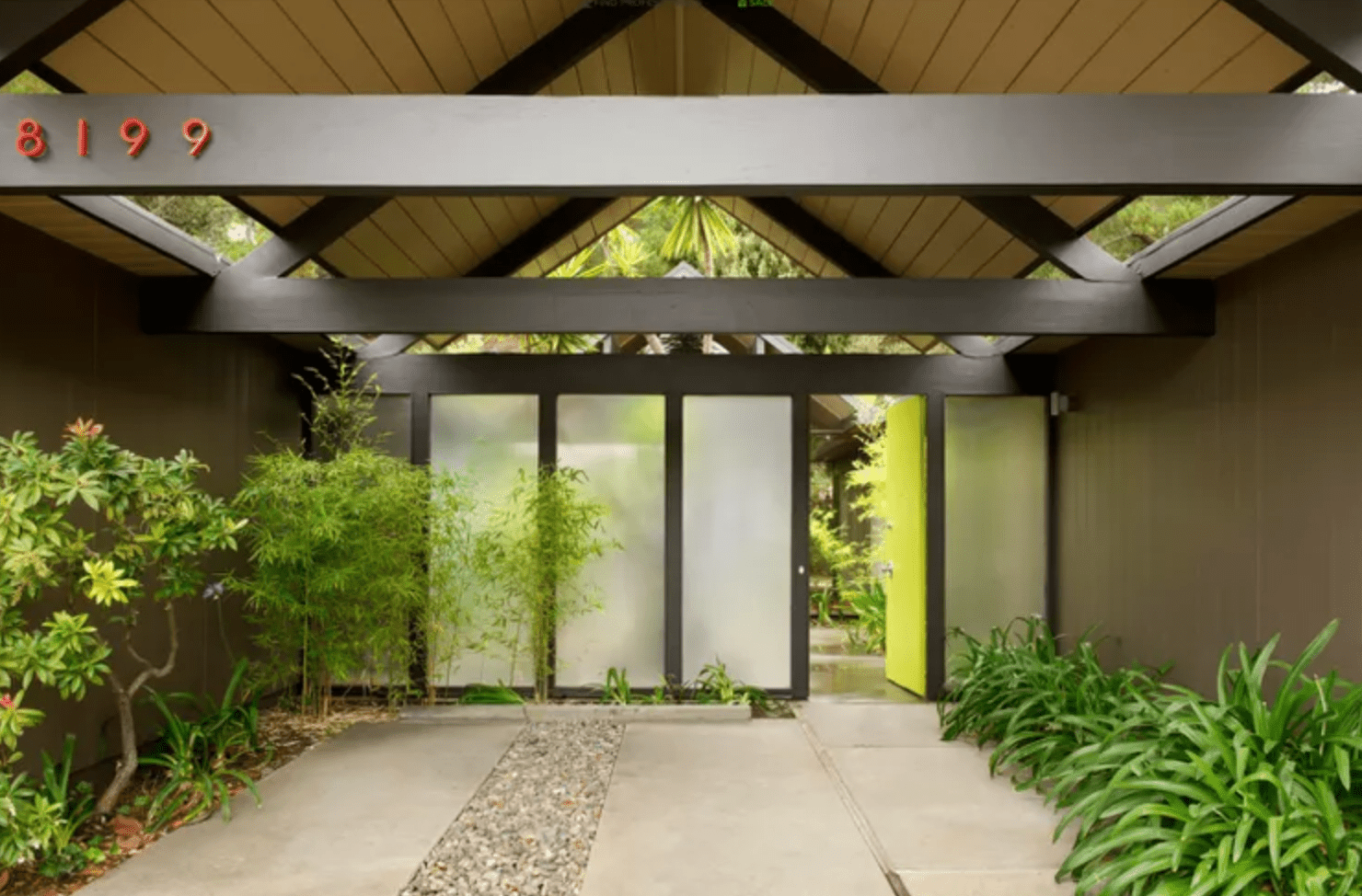 mid-century home with arched roof and plants