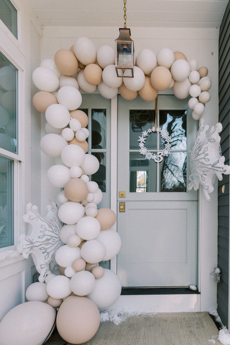 Un elaborado arco de globos en la entrada de una casa