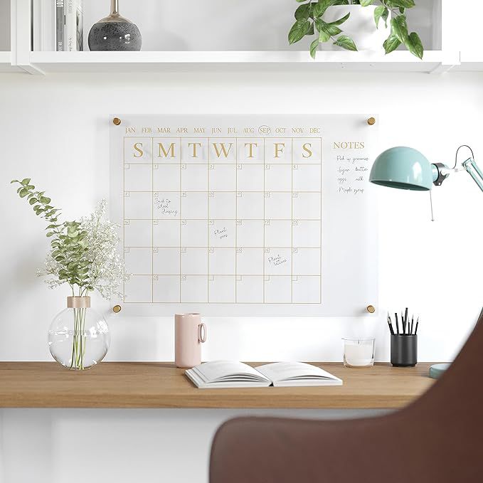calendário mensal afixado em uma parede acima da escrivaninha