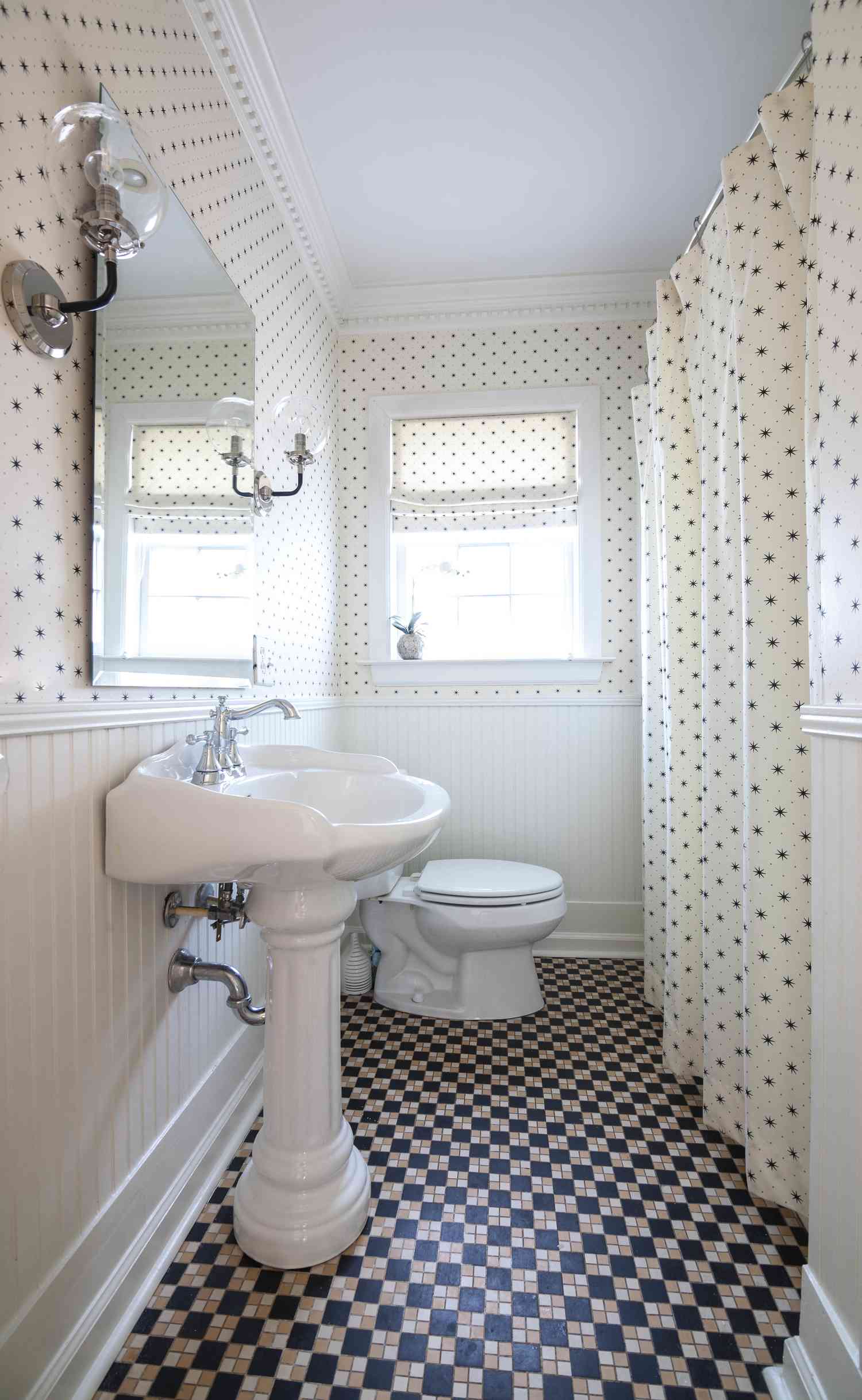 Um banheiro com paredes de bolinhas e cortina de chuveiro