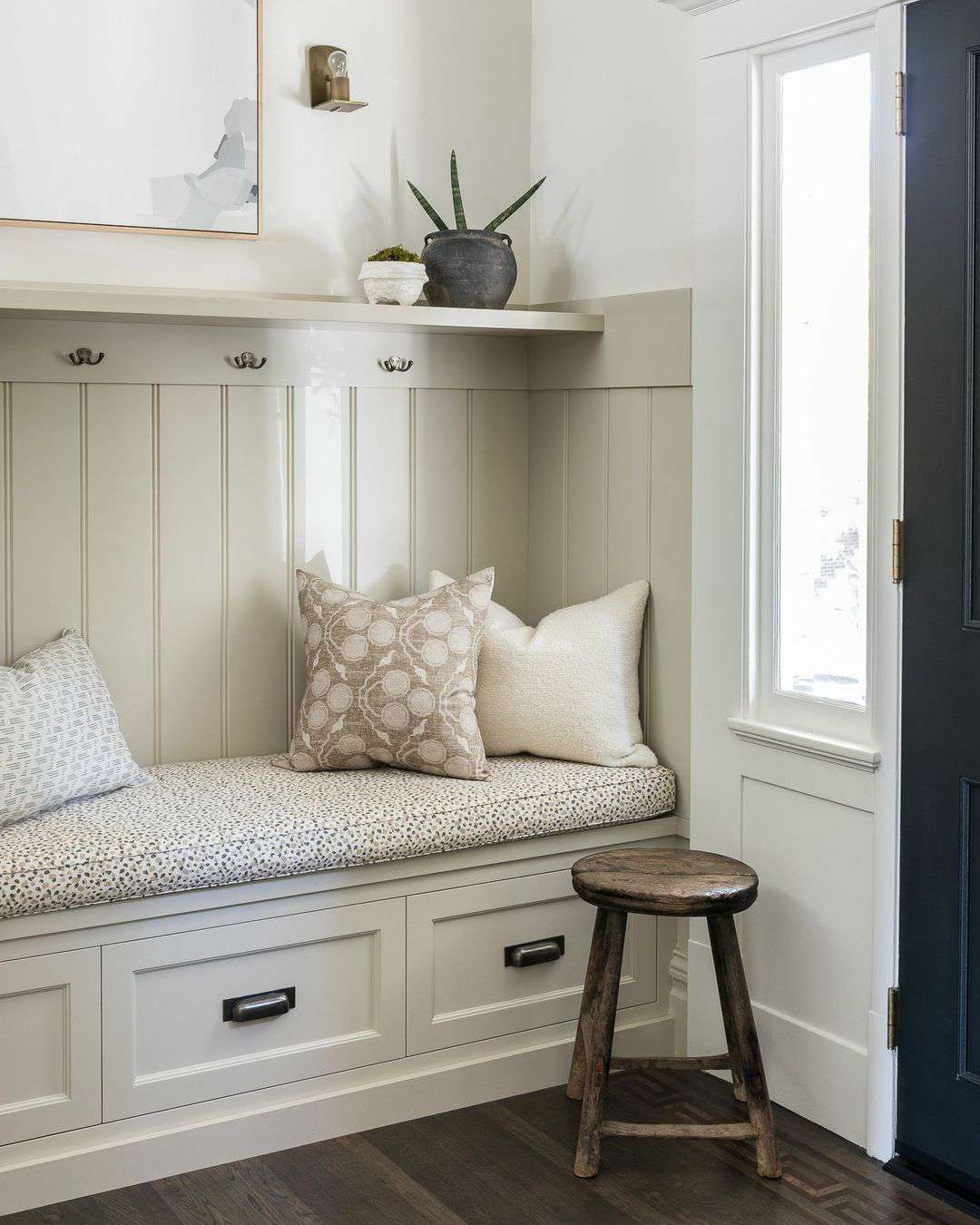 chair rail in a mudroom nook with a built in bench and coat hooks