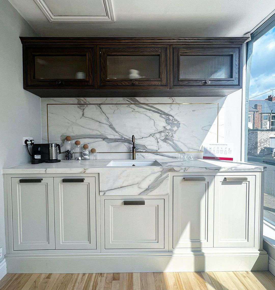 Cozinha branca com armários superiores de madeira marrom