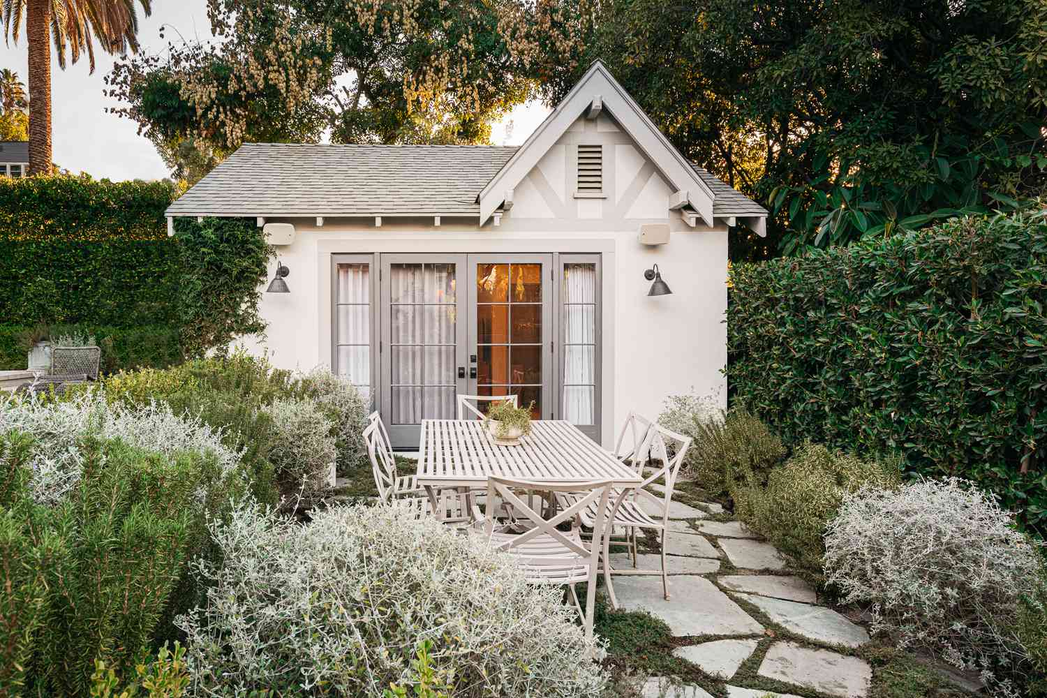 Pequeno quintal com paisagismo de tema branco e casa de hóspedes