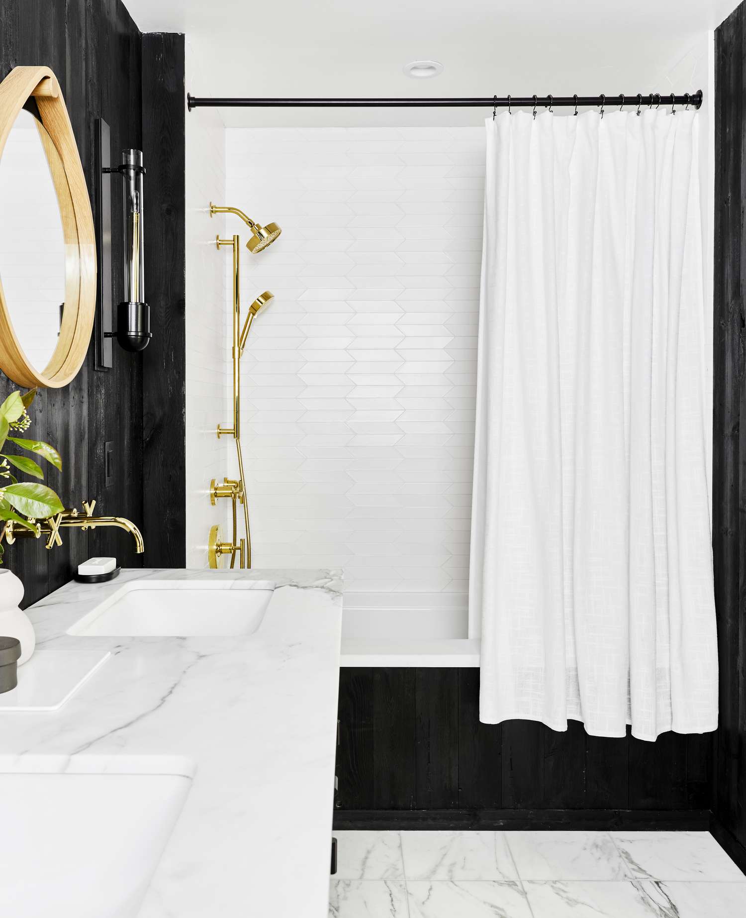Um banheiro preto tem uma cortina de chuveiro branca pendurada sobre a banheira