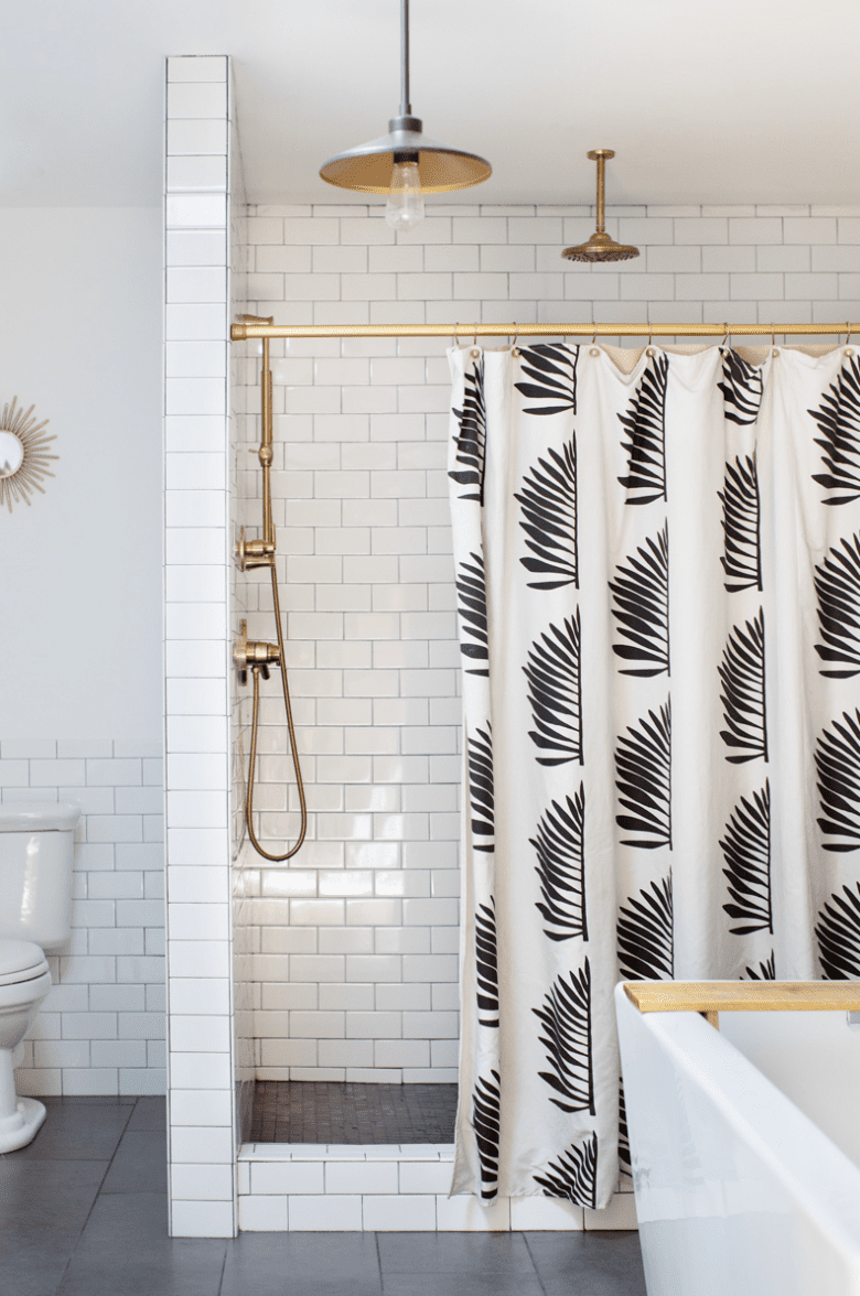 Um pequeno banheiro primário com uma cortina de chuveiro com estampa arrojada