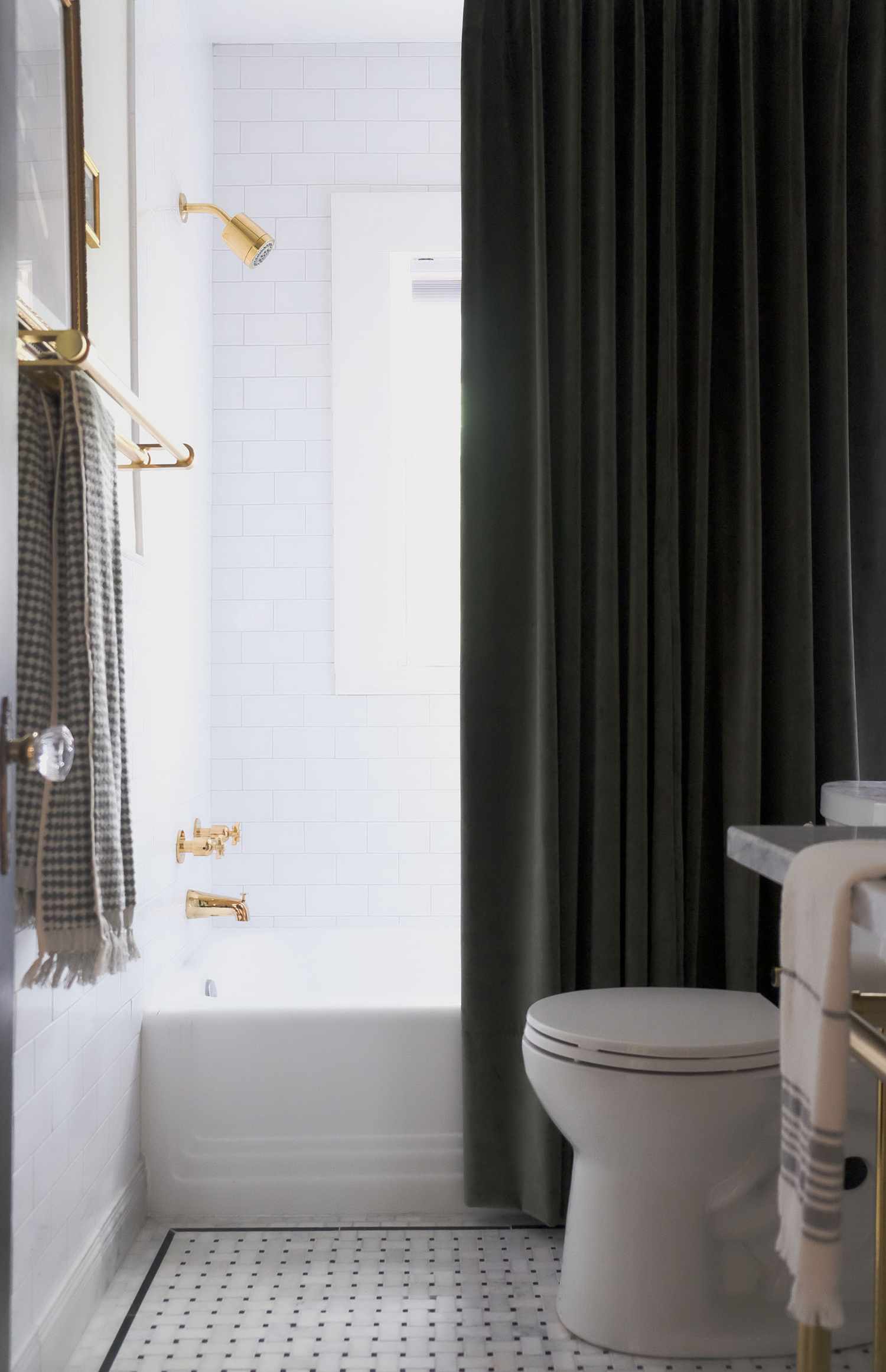 Uma cortina de chuveiro alta e escura se destaca em um banheiro quase todo branco