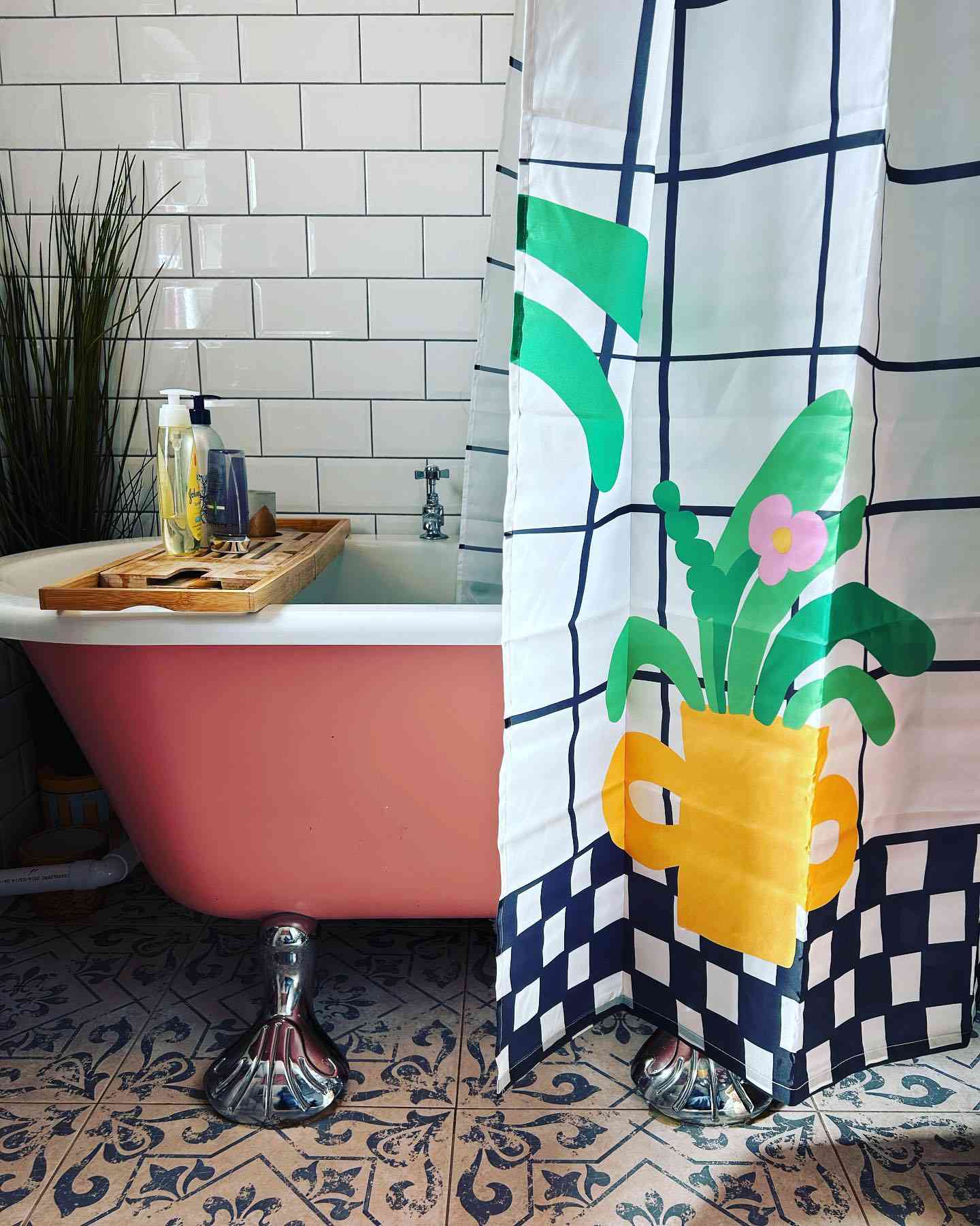 Badezimmer mit rosa Krallenfußwanne und Pflanzenduschvorhang