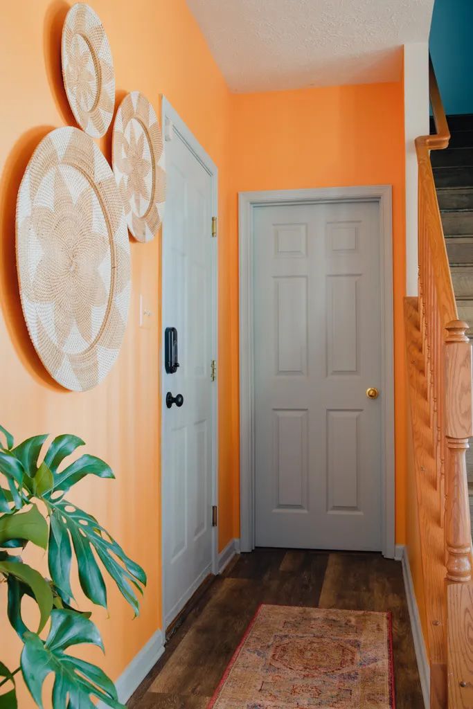 Pasillo naranja con puertas grises y cestas colgantes en la pared