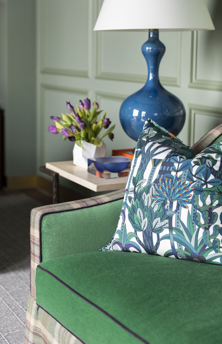 Kellygrünes Sofa und salbeigrüne Wände mit königsblauer Lampe