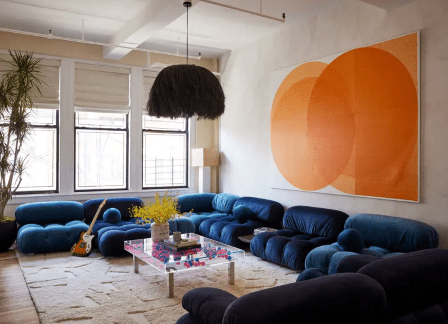 Königsblaues Sofa mit oranger Kunst