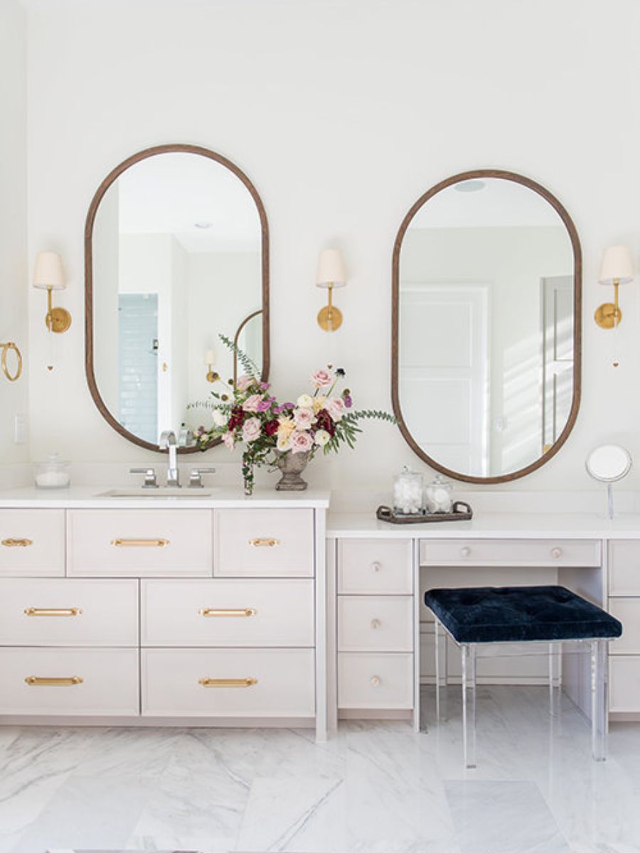 Elegante baño blanco con flores moradas.