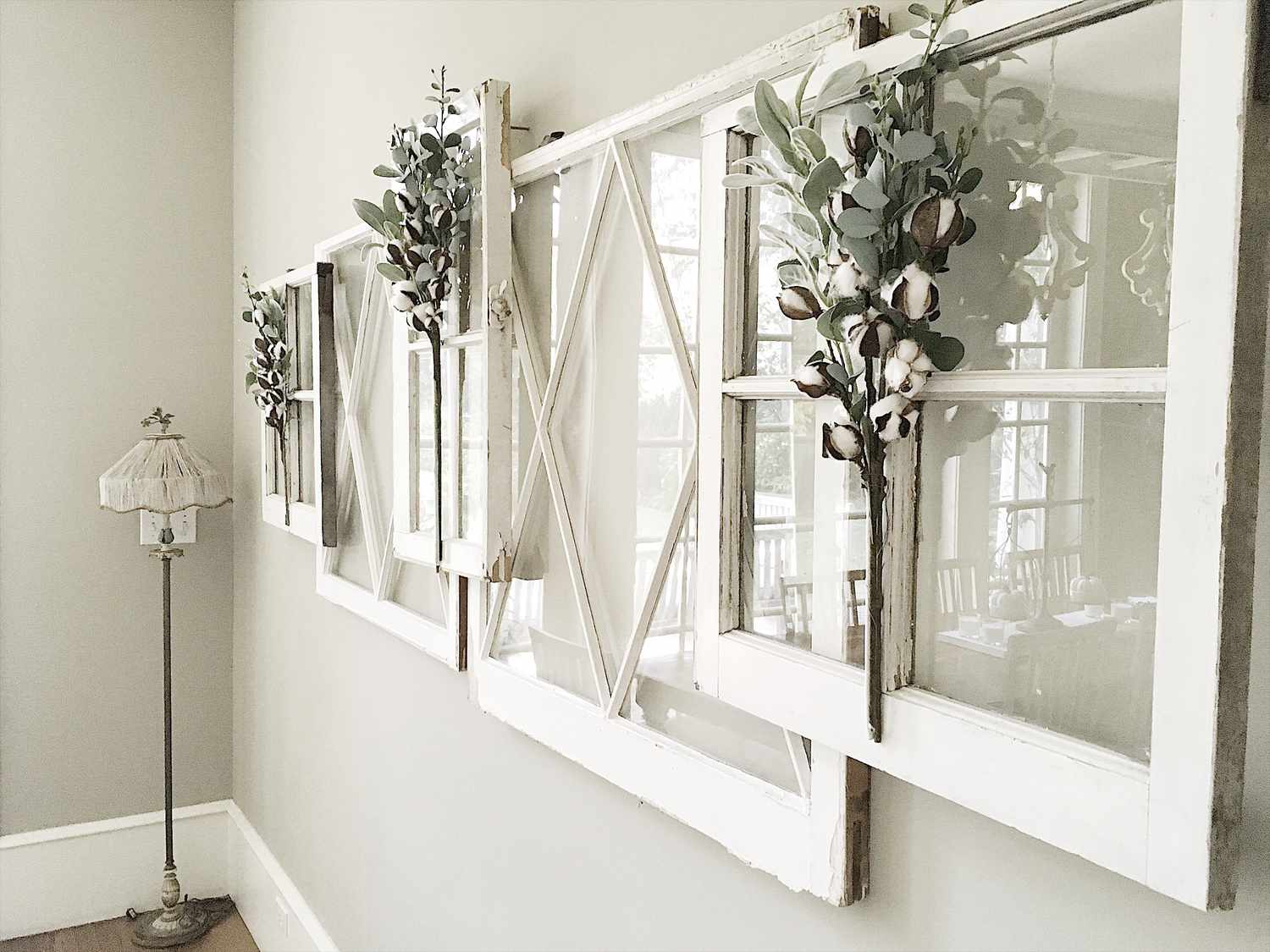 Una idea de decoración con marco de ventana colgando varias ventanas en una pared