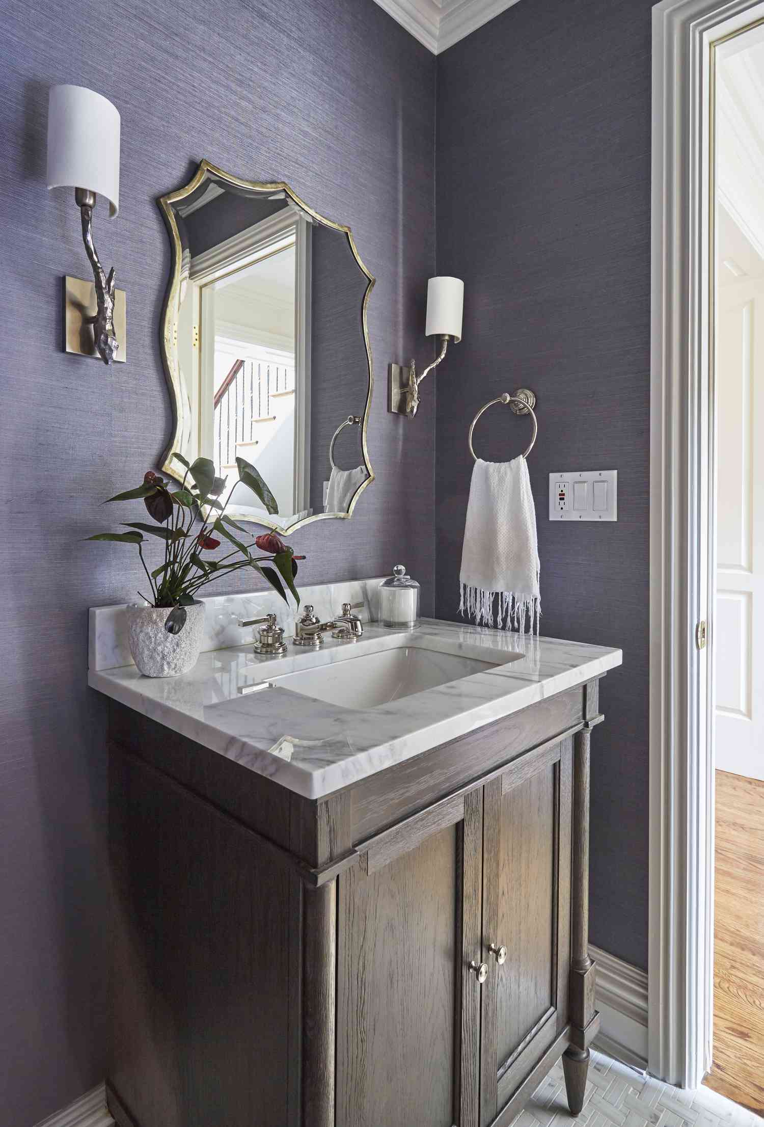Banheiro com papel de parede texturizado roxo.
