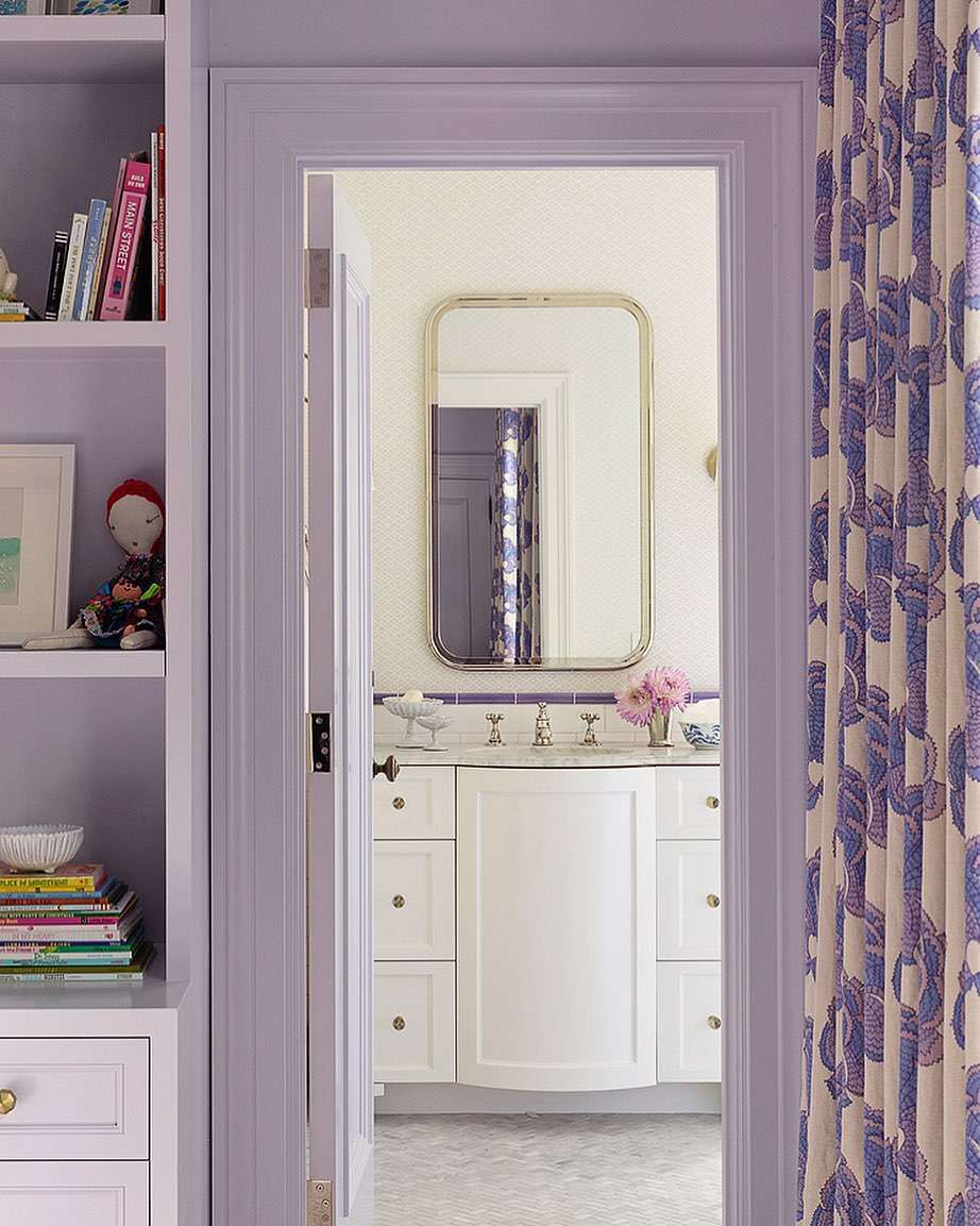 Baño blanco con borde de azulejo morado para salpicaduras.