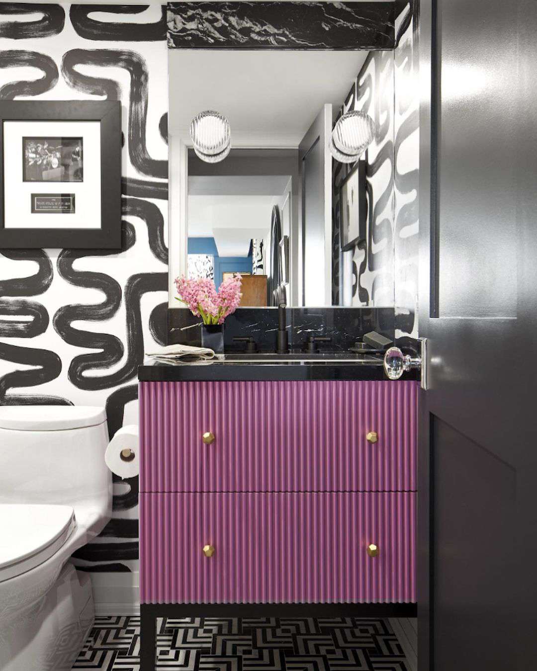 Baño blanco y negro con tocador morado.