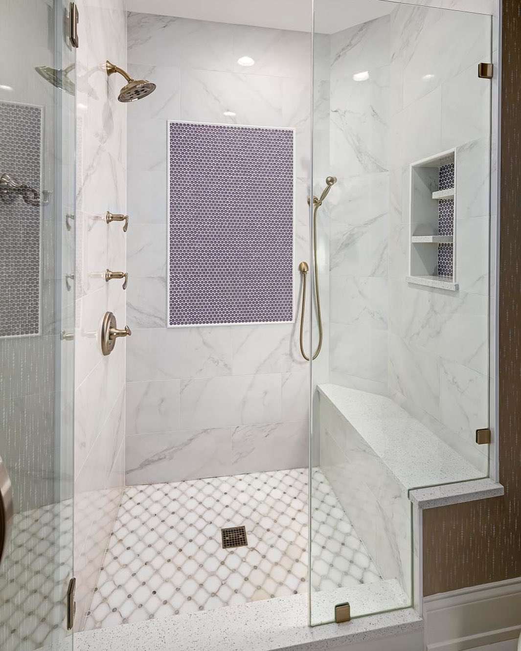 Purple tile accent feature in a white marble shower.