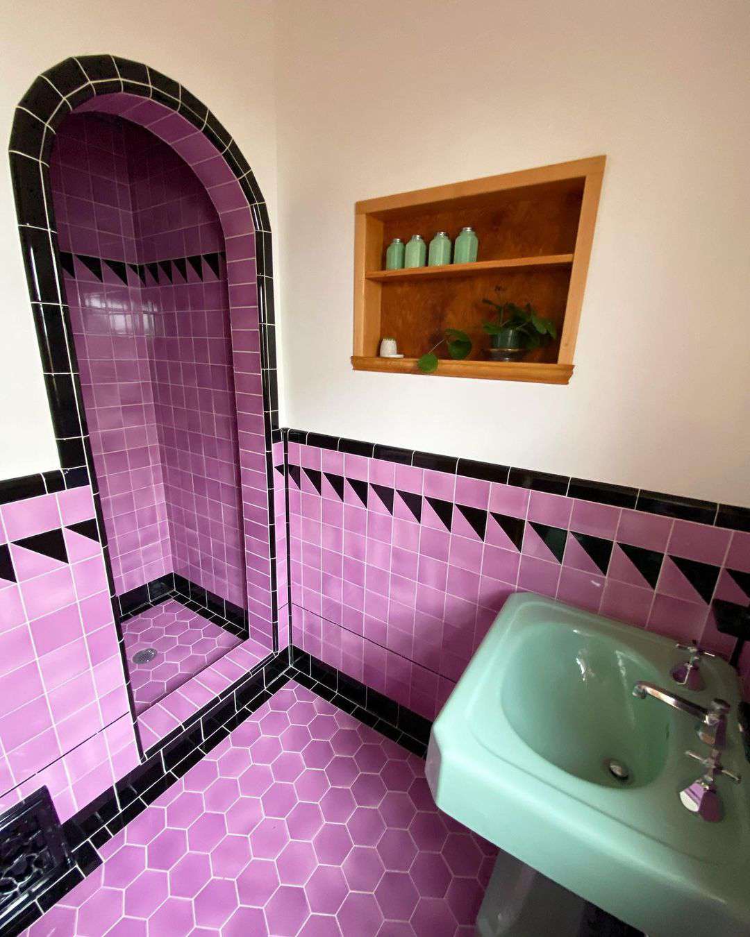 Salle de bain vintage avec carrelage violet et noir.