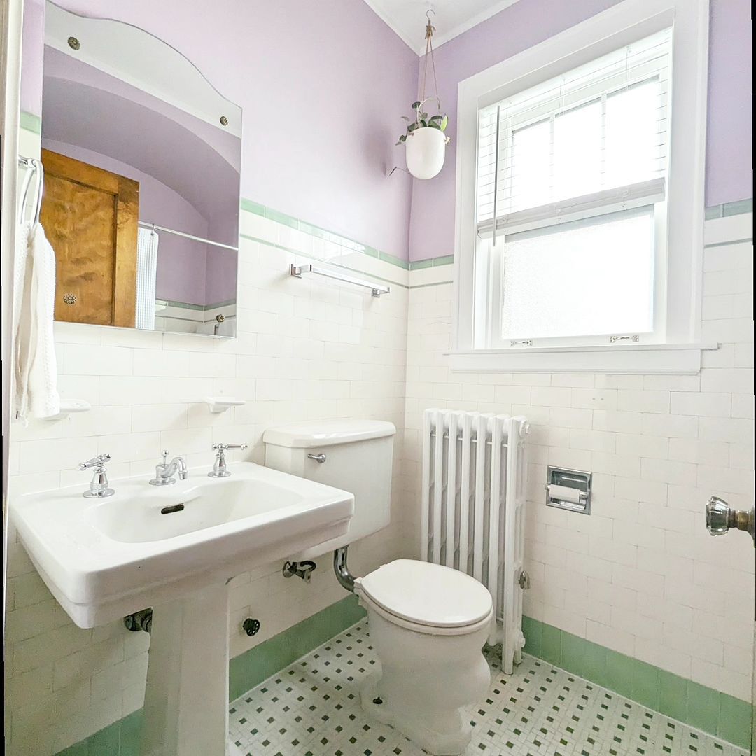 Salle de bain de style vintage avec murs violets et carrelage vert menthe.