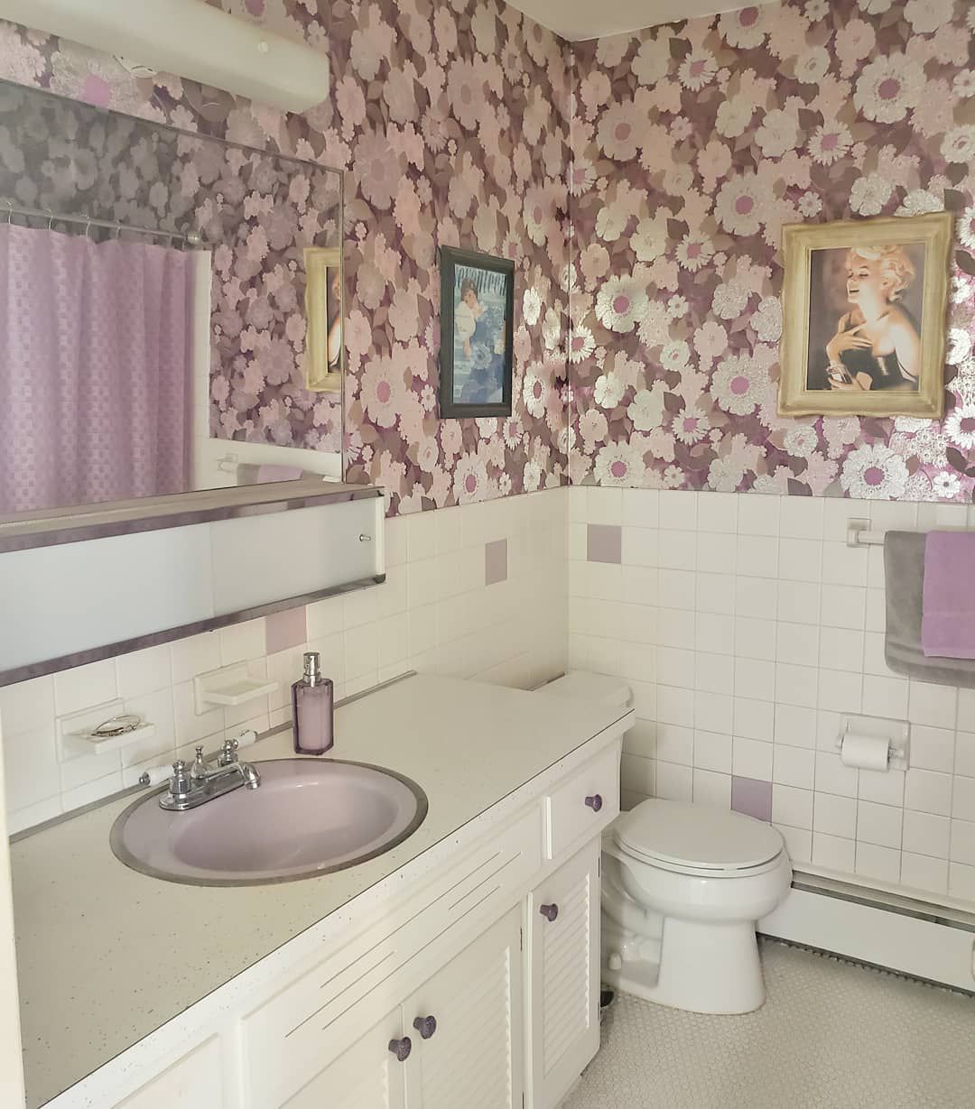 Salle de bain avec papier peint floral violet.