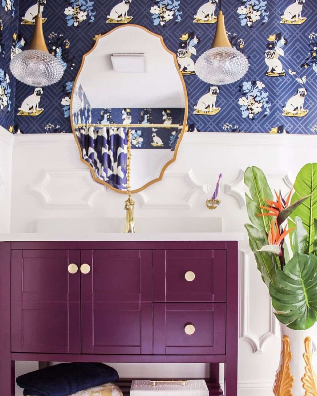 Salle de bain avec panneaux muraux ornés et meuble-lavabo violet.