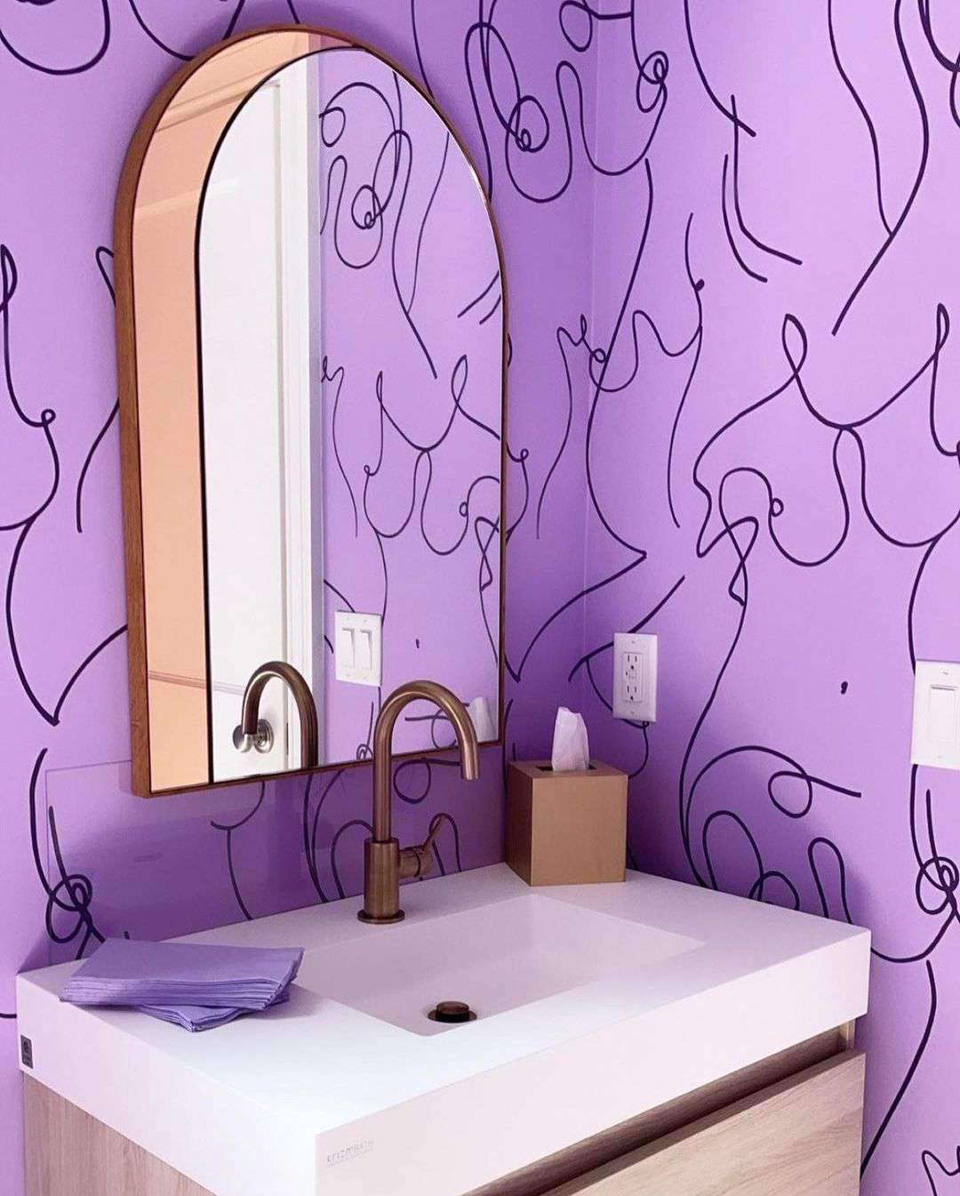 Cuarto de baño con papel pintado púrpura brillante y negro.